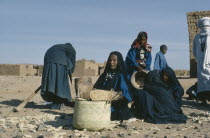 Group of Tuareg women with basket of grain.Nomadic muslim minority of Berber origin Moslem Colored Coloured