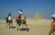 Tourists on camels visiting the pyramids