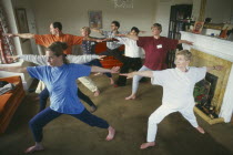Group of men and women doing Hatha Yoga in a living room