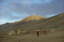 Kirghiz yurts in bleak mountain landscape.