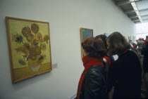Visitors inside the Van Gogh Museum looking at painting of Sunflowers.Netherlands
