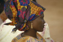 Hausa woman in traditional head dress.  Head and shoulders portrait profile right.