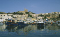 Fishing boats in harbour overlooked by cathedral.