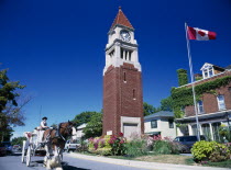Queen Street Clock Tower with Canadian flag flying. Horse and carriage travelling along roadAmerican Canadian Equestrian North America Blue Holidaymakers Northern One individual Solo Lone Solitary To...