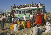 Over crowded bus with passengers on the roof