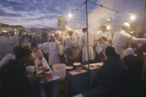 Djemaa el Fna. Food vendors serving up food to hungry customers seated around them at duskMarrakech