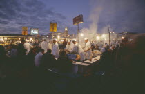 Djemaa el Fna. Food vendors serving up food to hungry customers seated around them at duskMarrakech
