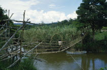 Napu Valley. Bamboo bridge over river with people crossing over.