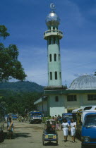 Rantepao Mosque. View down street with cars and people towards green Mosque.