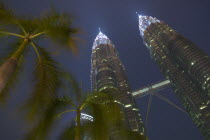 Angled view looking up at the Petronas Towers at dusk.