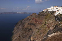 View along rugged coastal cliffs with the white architecture of the town nestled on the clifftopThira Fira Santorini