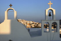 Bell tower of whitewashed church overlooking the townThira Fira Santorini