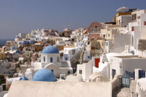 View over the towns predominantly white architecture with blue domed buildingsThira Fira Santorini