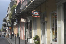 French Quarter. View along row of pastel coloured shops with ironwork balconies above