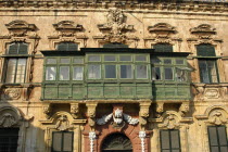 Section of building facade with green painted enclosed balcony