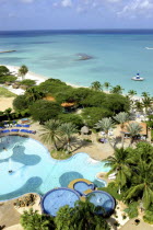 View over beach side hotel pool with clear blue sea beyond