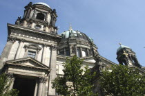 Angled view looking up at the Berliner Dom with green copper domes