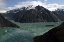 View over rocky cliff edged waterways toward mountain peaks