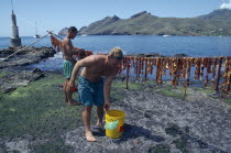 Marquesas  Nuku Hiva.  Men air drying beef in coastal area.