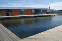 Water Colour Museum.  Modern building with water and wooden decking in foreground. Color