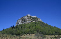 Ruins of eleventh century Peyrepetuse Cathar Castle on top of rocky hillside.
