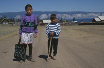 Buryat children with farmstead and lake behind.  The Buryat are of Mongolian descent and are the largest ethnic minority group in Siberia.