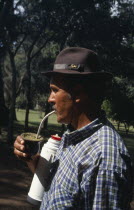 Gaucho drinking mate a traditional South American herbal drink made from yerba.  The name can refer to both the drink and vessel from which it is drunk.