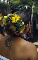 Marquesas Islands.  Ua Huka.  Dancer wearing umuhei head dress of mint  hibiscus and frangipani flower and with tattoo of swordfish between her shoulder blades.