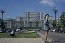 House of the Republic.  Palace of former Communist president Nicholae Ceausescu.  Exterior facade with young woman standing in foreground.