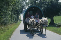 Danish family on holiday in caravan drawn by pair of Norwegian Fjord ponies.