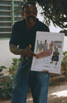 Male teacher using story boards to demonstrate AIDS awareness and safe sex message.