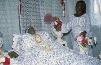 Deceased woman lying in state at funeral with female attendant.  This is common of Ghanaian funerals as a large wake but not usual for muslims.   South