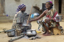 Women cooking banku a fermented corn and cassava dough cooked to a paste in hot water and served with soup  stew or a pepper sauce with fish.