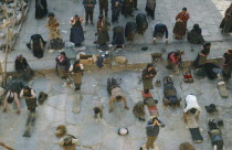Pilgrims prostrate themselves and pray in front of Jokhang Monastery.