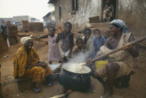 Women and children cooking Fufu the national delicacy of pounded yams in a small village near the capital city