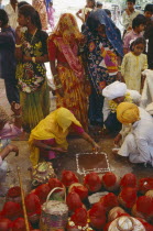 Mourners at memorial service for recently deceased man. Pots covered with red cloth contain holy Ganges water. Hindu