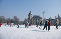 Ice skaters on outdoor rink.