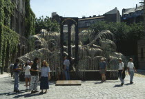 Dohany Street Synagogue.  Visitors beside Holocaust memorial designed by Imre Vaga in form of a weeping willow tree.