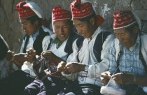 Taquile Island.  Line of men knitting.