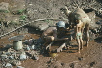 Men panning for gold watched by child.Brasil Brazil