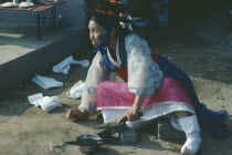 Shamanism.  Female mudang whose role is to act as an intermediary between the living and spirit worlds attending funeral.