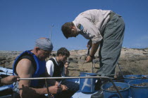 Inspector weighing catch of goose barnacle fisherman.  Fishing was banned for a year after the 2002 Prestige oil disaster and daily catches are limited to six kilos.Coast of Death  Percebeiro