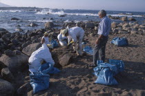 Cleaning squads removing oil from rocky coastline one year after the Prestige oil disaster.Coast of Death