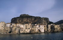 Town houses on edge of water with huge rock behind once the site of a Temple of Diana.