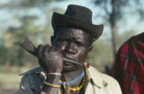 Portrait of a Dodoth Karamojong warrior blowing an antelope horn to call a meeting of other warriors and elders.Pastoral tribe of the Plains Nilotes group related to the Masi
