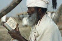 Ethiopian Orthodox priest in Sudan reading from the Bible.