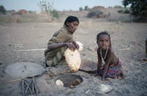 Afar woman and child cooking in oven in ground.Cushitic speaking pastoral nomads aka Danakil and Adali