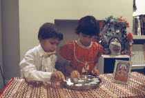 Diwali Hindu Festival of lights with children lighting candles beside a picture of Lakshmi