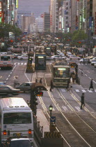 Aioi Street with city traffic either side of a central tram line and skyscrapers on each side of the road