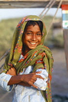 Smiling Sindhi gypsy girl wearing head dress. romany